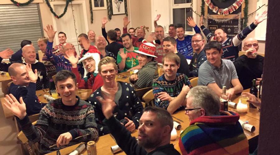 Guys at a youth hostel Christmas party wearing Christmas hats 