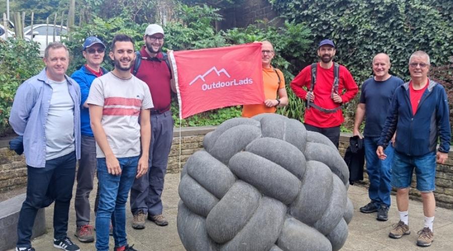 ODL members with red flag behind a sculpture of a knitted ball