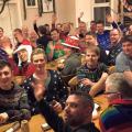 Guys at a youth hostel Christmas party wearing Christmas hats 