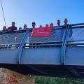 ODL members with red flag behind a sculpture of a knitted ball
